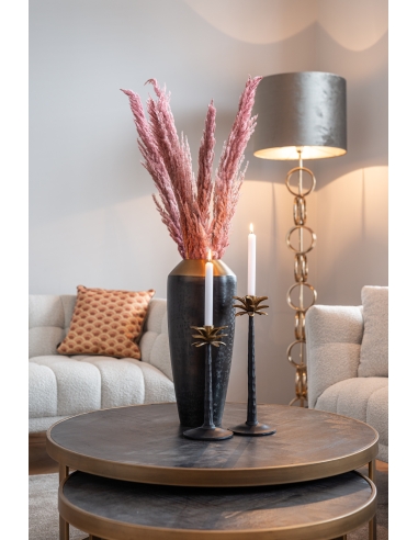 Vue rapprochée des tables BLACKBONE avec un vase noir, des herbes roses et deux chandeliers entre des assises claires